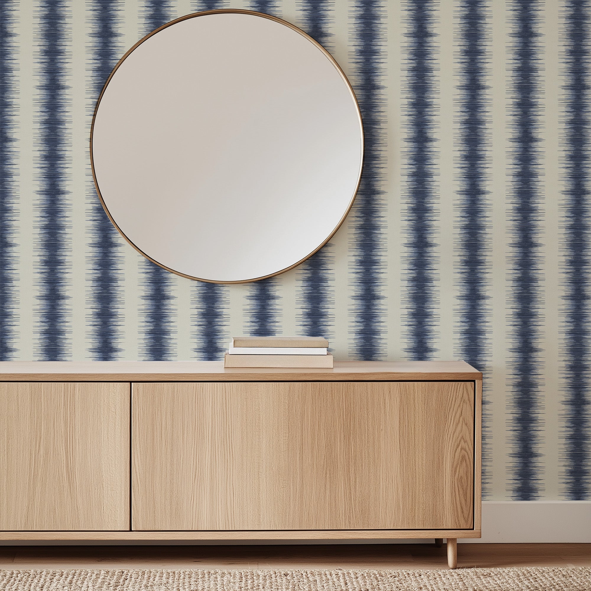 Wooden cabinet with a round mirror against a striped wallpaper wall.  Abstract stripe wallpaper pattern with textured, irregular vertical bands that create organic movement and a modern, layered look inspired by natural rhythm. Blue white ivory, Les Touches