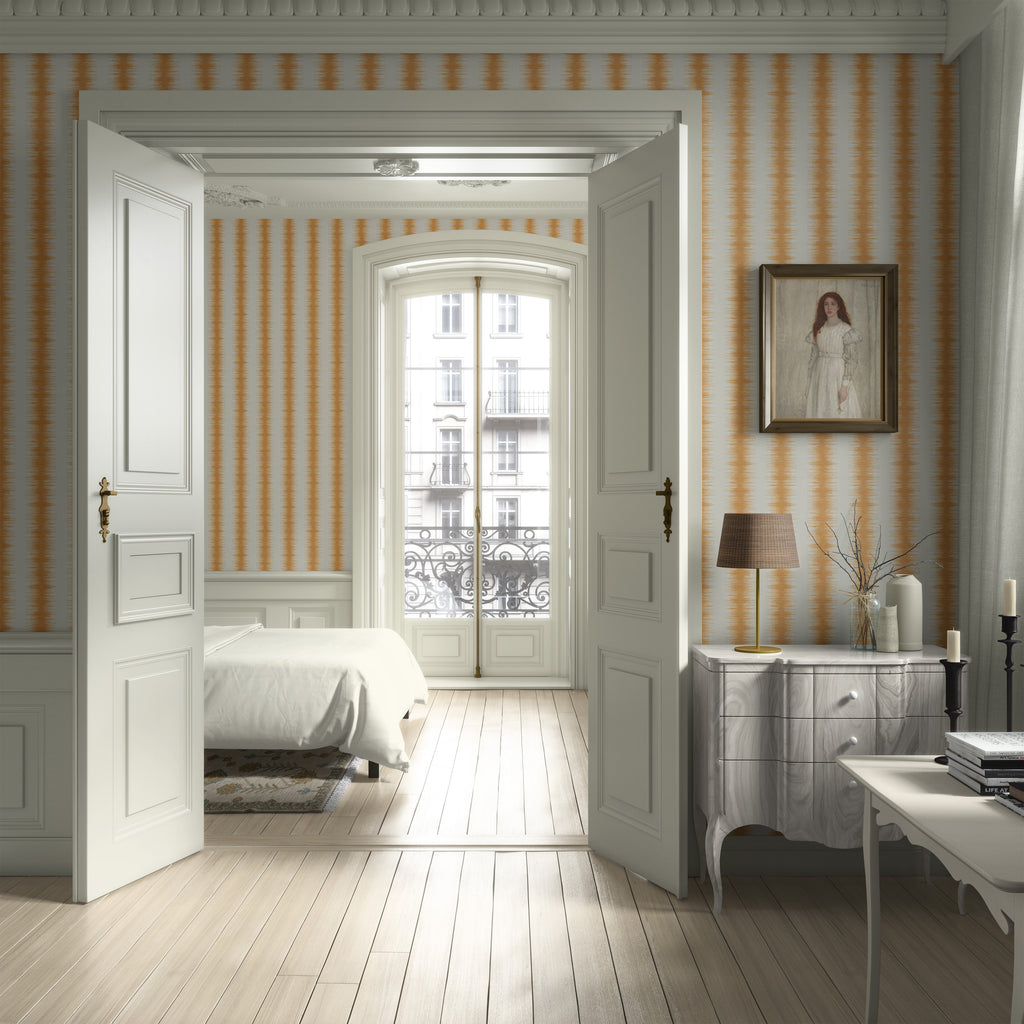 Neatly arranged bedroom with striped wallpaper and a bed. Abstract stripe wallpaper pattern with textured, irregular vertical bands that create organic movement and a modern, layered look inspired by natural rhythm. Yellow ivory white, Les Touches